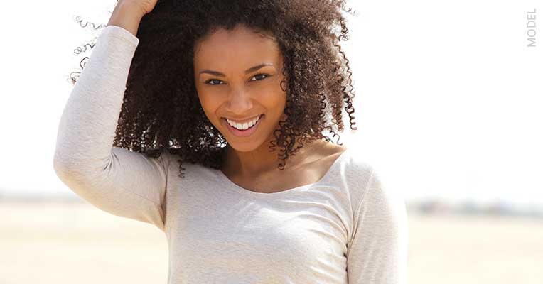 Model smiling and touching her hair