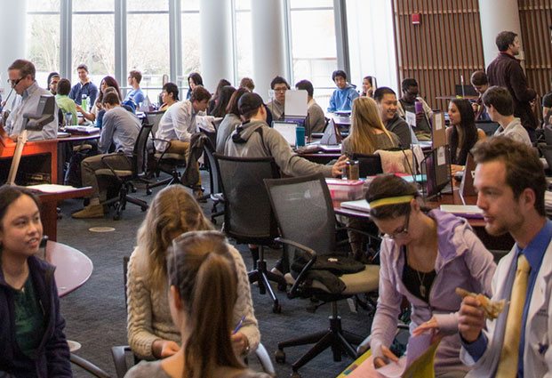 A room full of students studying and working together