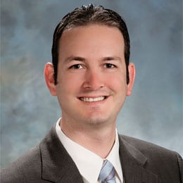 Headshot of Jonathan S. Black, MD, FACS, wearing a dark suit, white shirt, and necktie