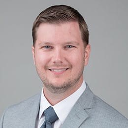 Headshot of Dr. DeGeorge wearing a grey suit and necktie