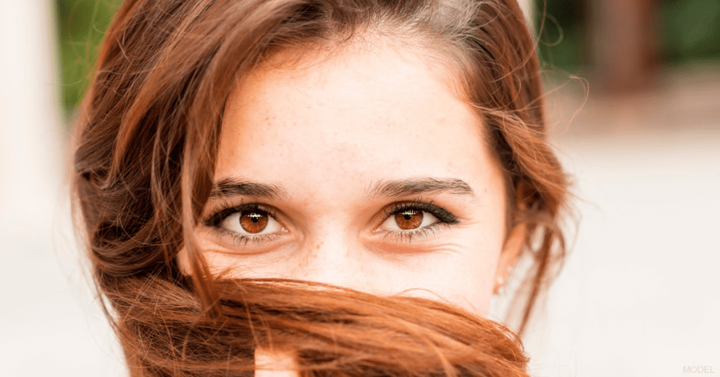 A woman covering her face with her hair