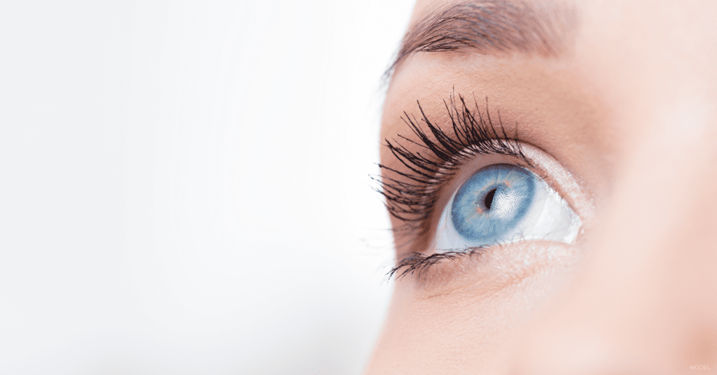 Closeup of young woman's blue eye looking up