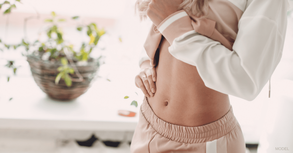 Woman with tight figure touching stomach