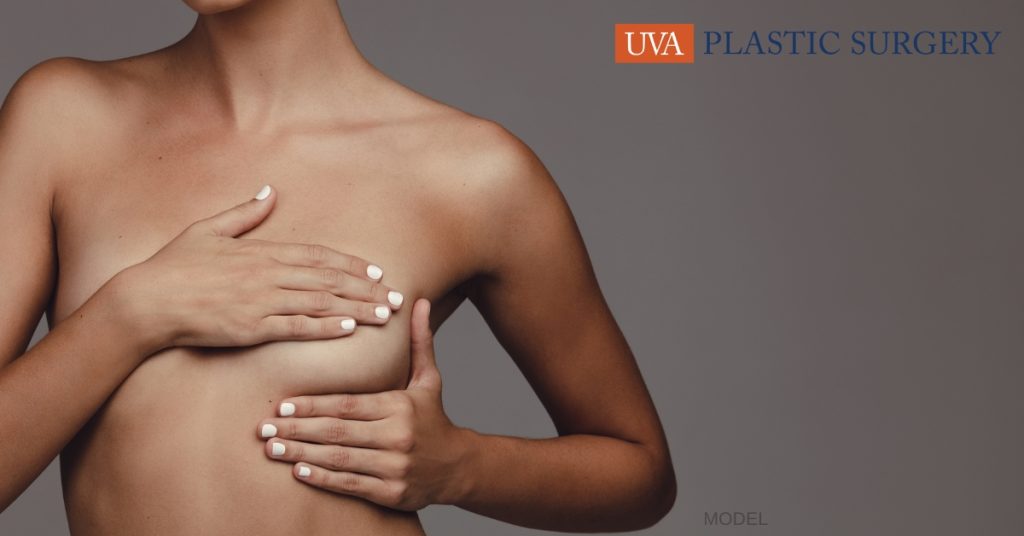 woman considering reconstructive breast surgery holding her body (model)
